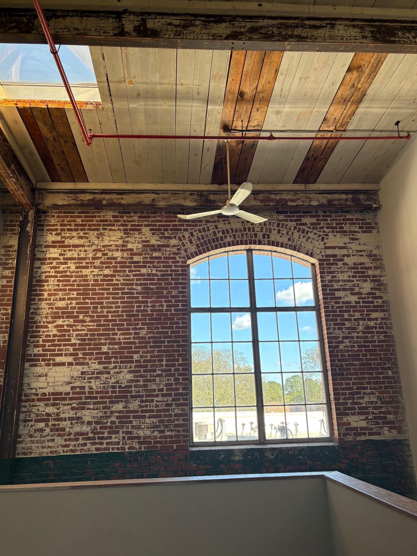 Loft with exposed brick walls and a large arched window